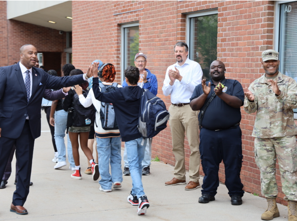 Jimmy McMikle and others greet Windsor High School students alongside more than a dozen Windsor fathers, mentors, uncles, grandfathers, and father-figures for “Calling All Windsor Men event organized by Office of Family and Community Partnerships Coordinator, Christina Morales and Dream Driver Foundation.”