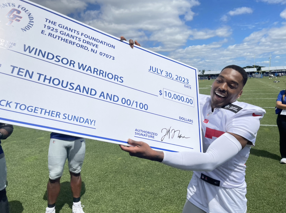 JAson Pinnock presents a $10, 000 equipment grant to the Windsor High School Football team on behalf og the giants foundation. 