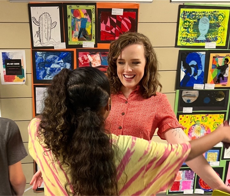 Ms Llyod embraces art student at JFK’s art show 