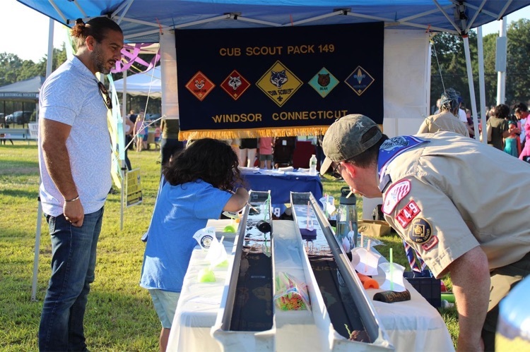 Cub Scout Vendor racing boats with WPS student 