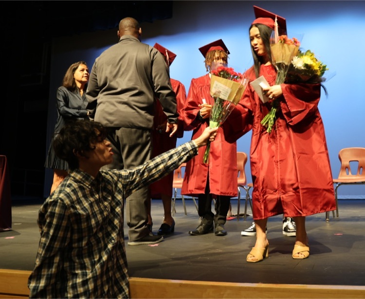 Mom of three, Windsor Adult Ed graduate receives flowers from one of her children.
